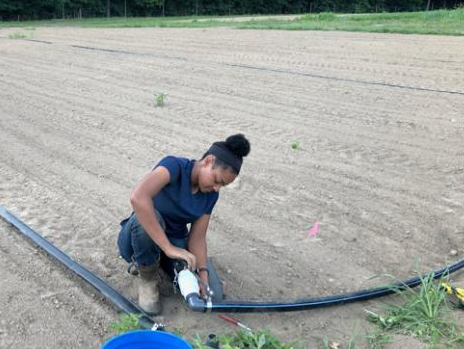 "Student working on irrigation piping"